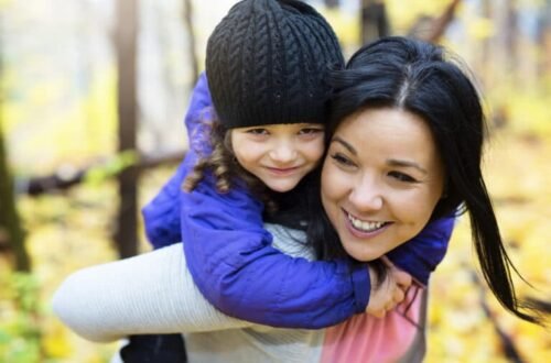 a,young,mother,playing,with,her,daughter,in,autumn,park